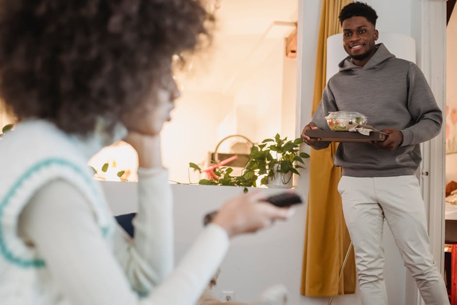 A young couple enjoying a relaxed moment at home with TV and delivery food.