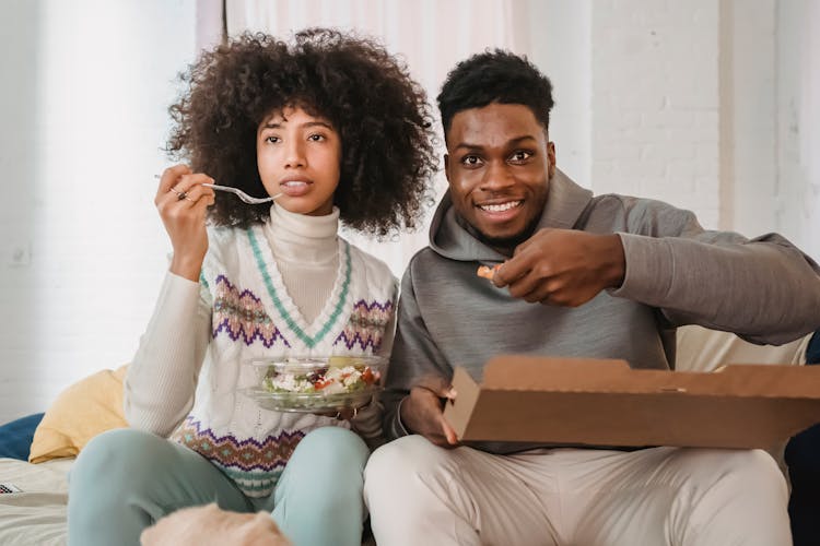 Happy Black Couple Having Snack With Pizza And Salad