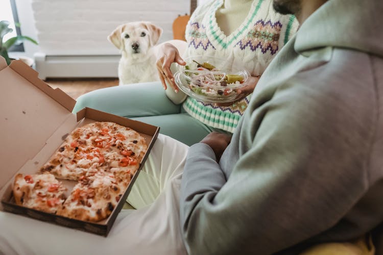 Black Couple Having Snack Near Curious Adorable Dog