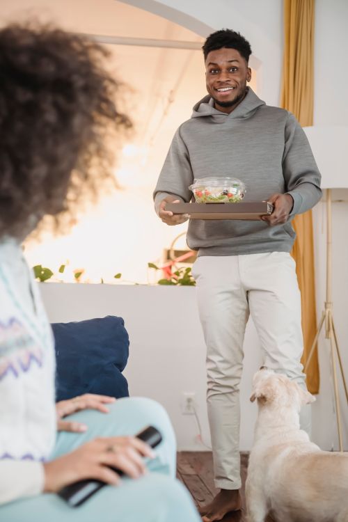 Free Crop anonymous African American girlfriend waiting for smiling boyfriend at home with fluffy dog Stock Photo