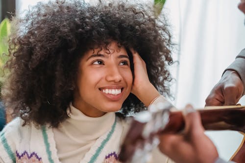 Free Positive black girlfriend listening boyfriend playing guitar Stock Photo