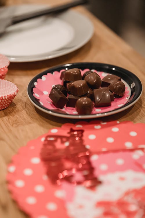 Homemade chocolate sweets on plate near festive cake