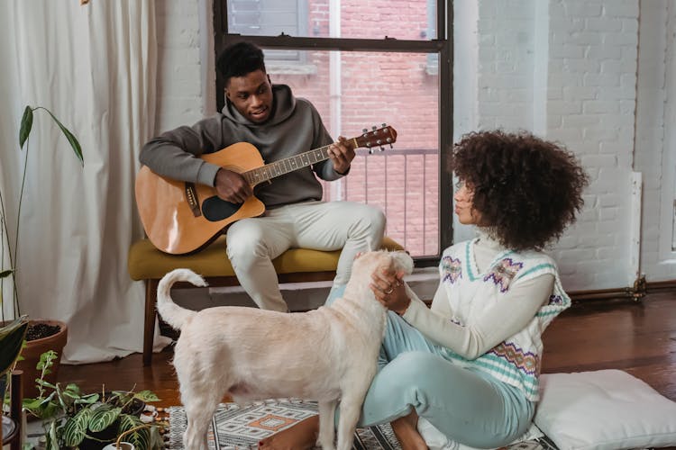 Black Man Playing Guitar For Girlfriend And Dog