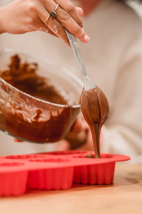 Crop woman pouring batter into mold