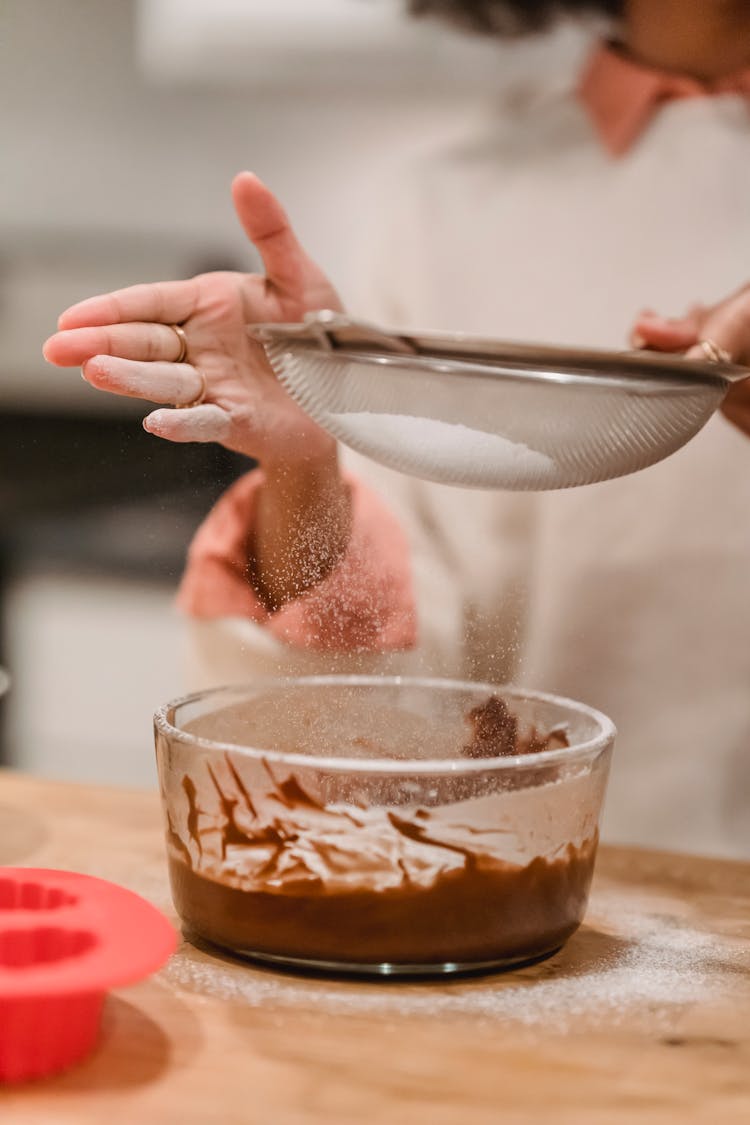 Crop Woman Sifting Flour Into Bowl With Batter