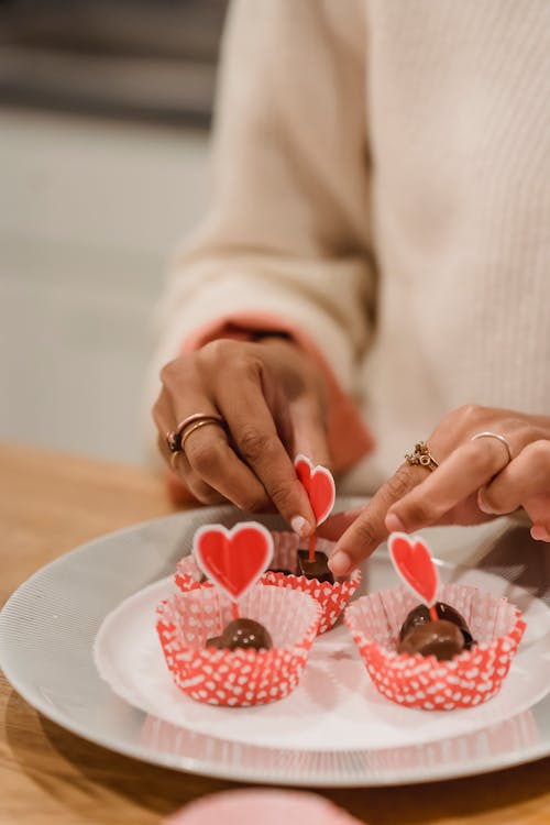 Free Black woman decorating festive sweets with hearts Stock Photo