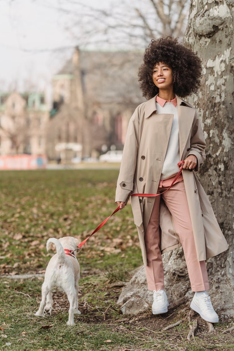 Positive Black Woman Walking With Little White Dog