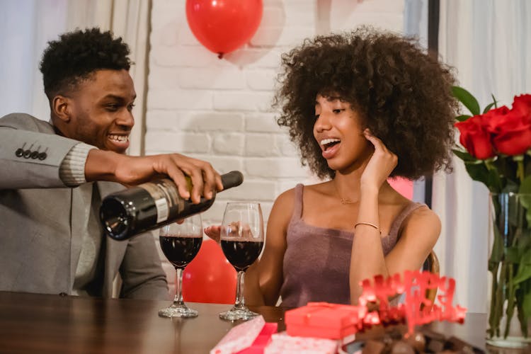 African American Couple Having Date At Table While Pouring Wine