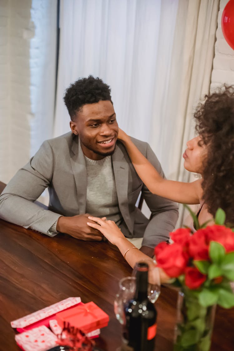 African American Couple Holding Hands While Having Date At Table