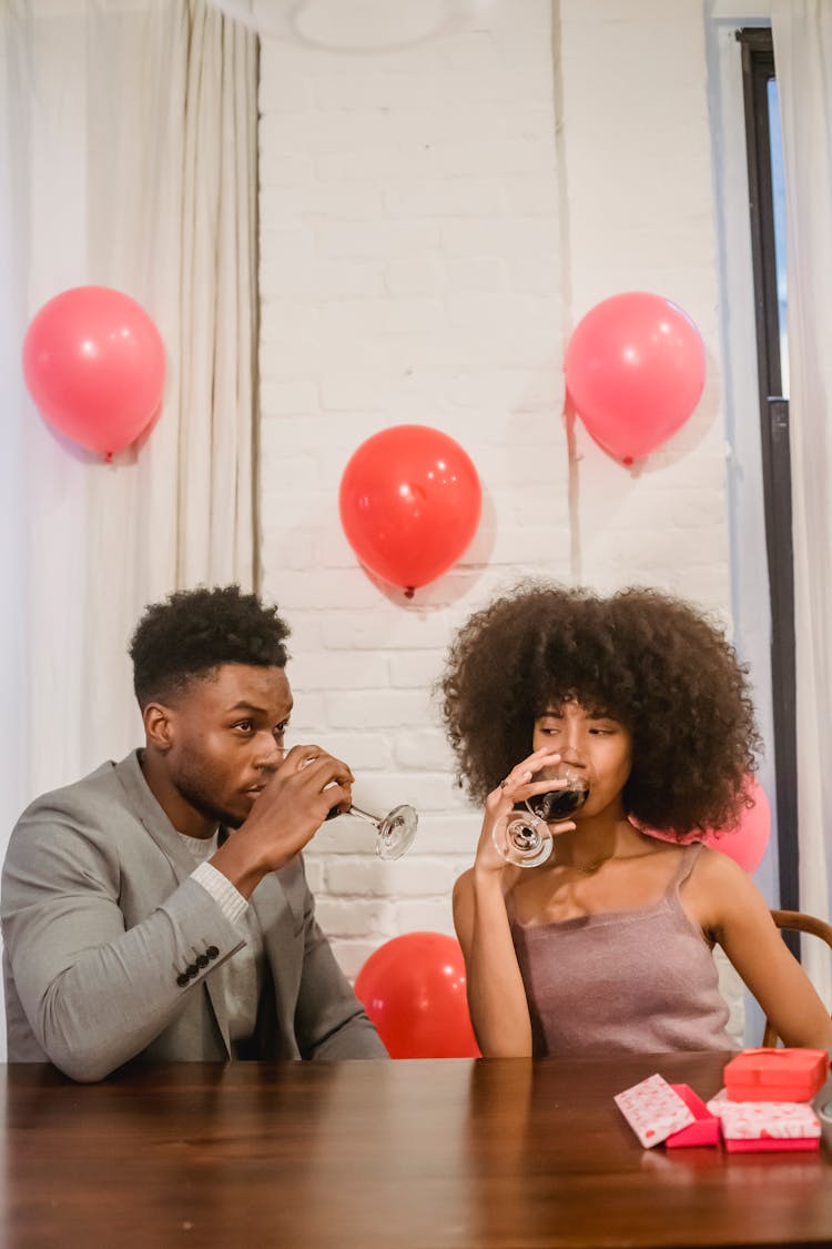 African American Couple Drinking Wine In Decorated Room