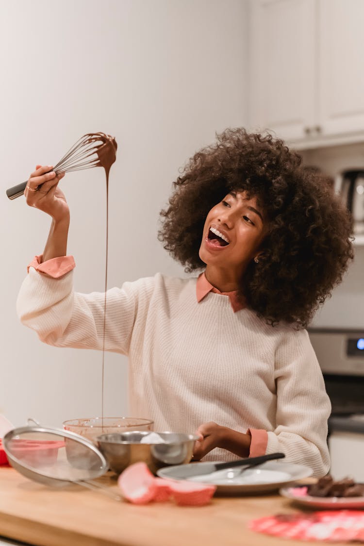 Delighted Black Woman With Whisk Covered With Batter