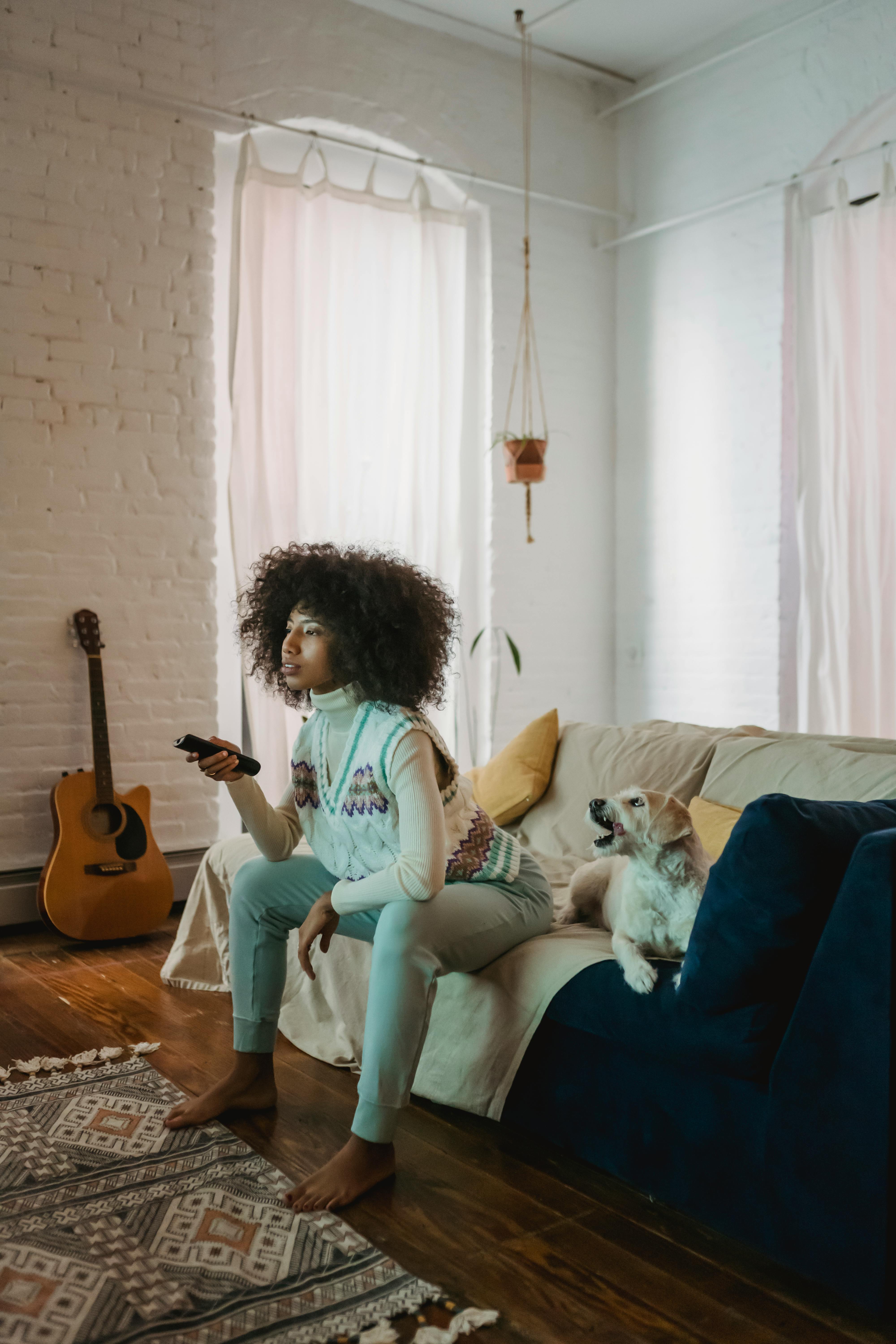 black woman watching tv near dog