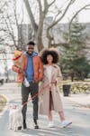 Free Cheerful black couple with dog on street Stock Photo