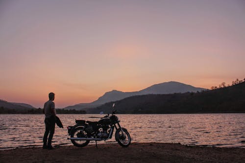 Free A Man Standing Near the Motorcycle Stock Photo