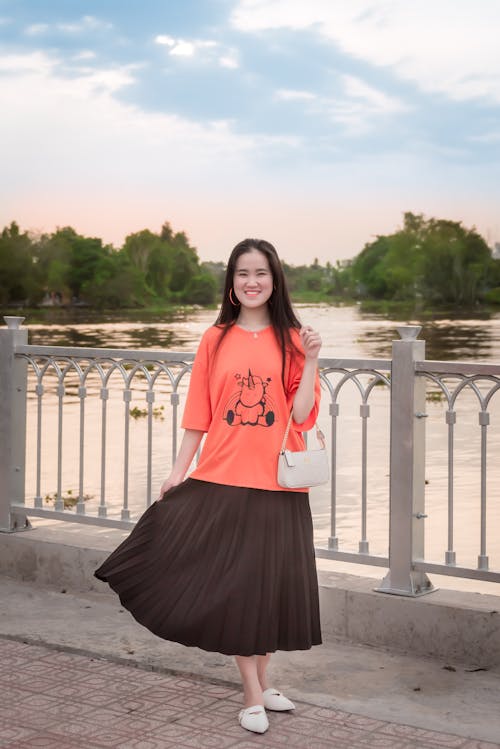 Woman in Orange Top and Brown Skirt