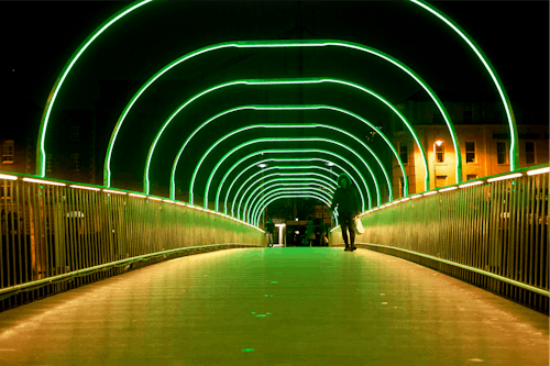 Man Walking on the Bridge with Neon Lights 