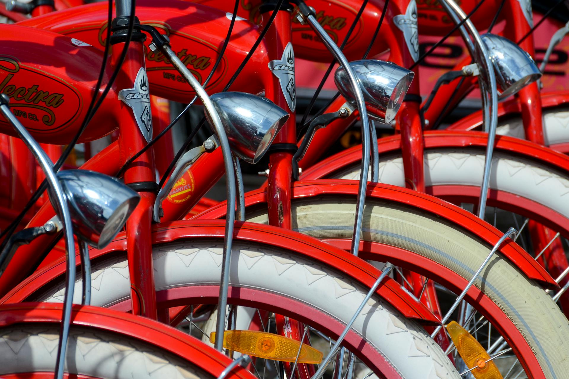 Detailed view of vibrant red vintage bicycles with chrome accessories and white tires.