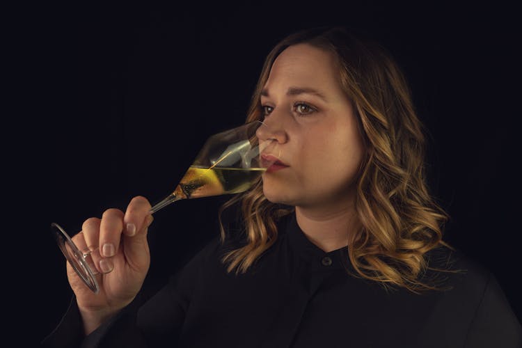 Emotionless Woman Smelling Aromatic White Wine