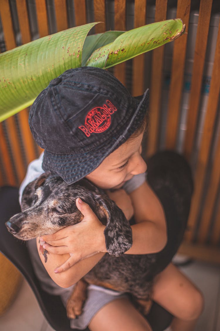 Boy Hugging A Dog