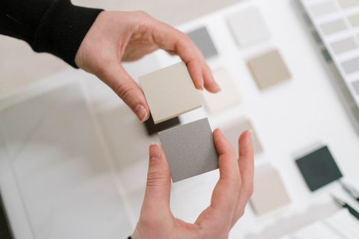 Hands holding neutral color swatches for interior design selection.. hands, holding, neutral