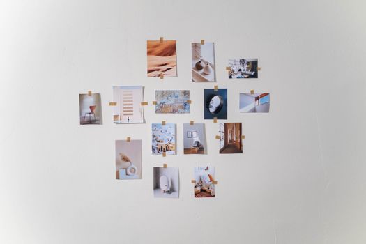 Aesthetic arrangement of photos on a white wall in a minimalist style.