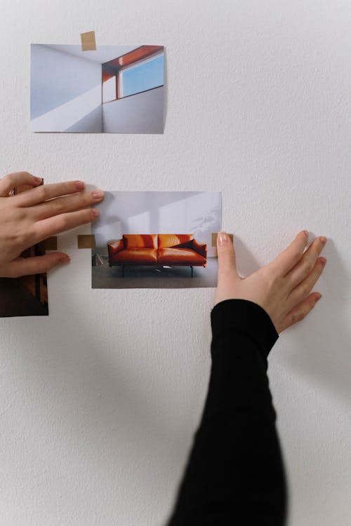 Person sticking a Picture on a Wall 