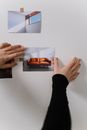 Person sticking a Picture on a Wall