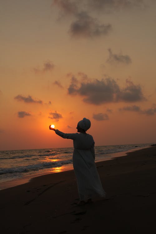 Free Silhouette of Person standing on a Beachside  Stock Photo