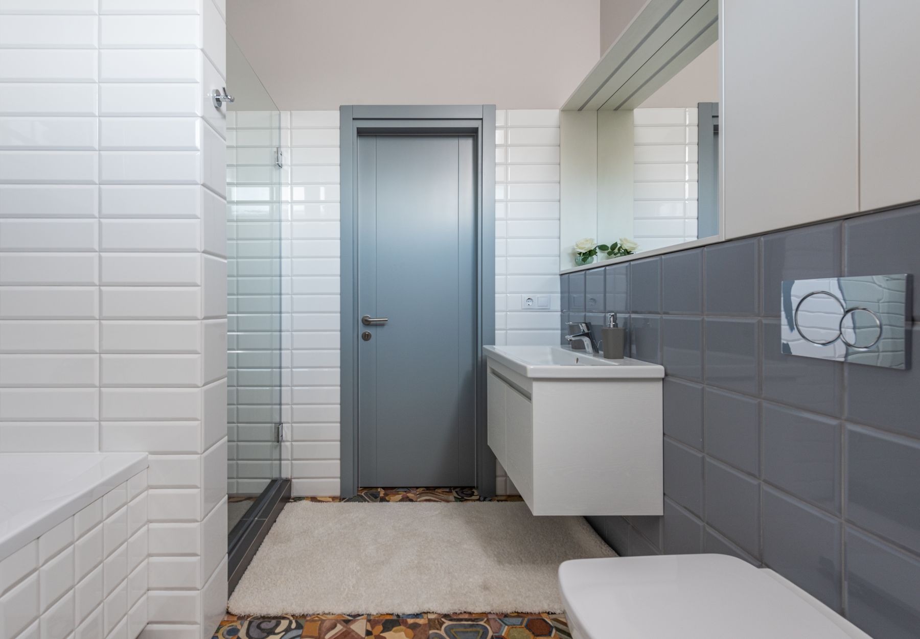 Modern bathroom in layered white and grey tones with a basin, shower and integrated fixtures