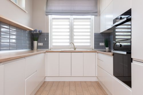 Free Interior design of modern kitchen in minimal style and furniture with smooth surface and windows with jalousie Stock Photo