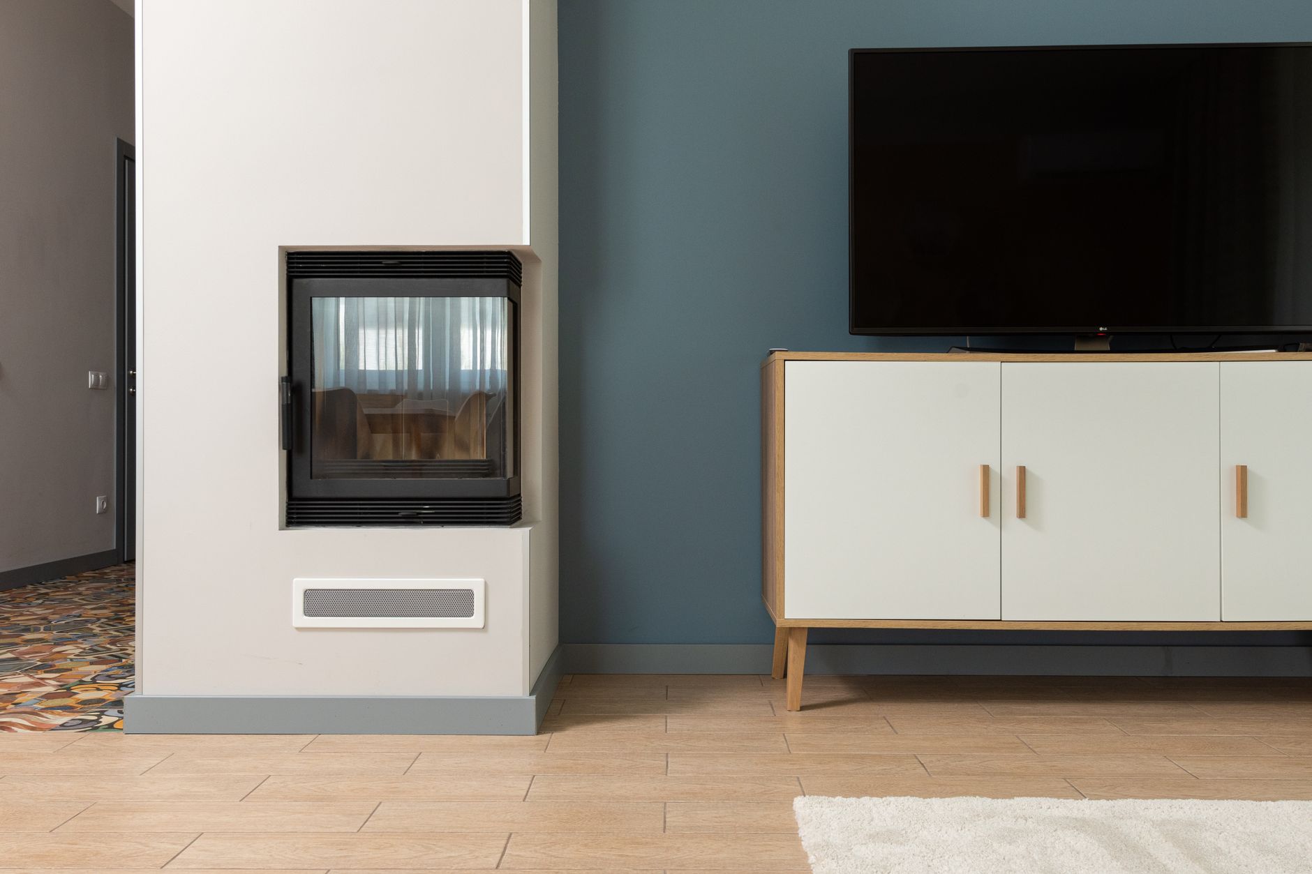 Modern living room television showing a JioHotstar movie menu, with remote control and subscription notes nearby