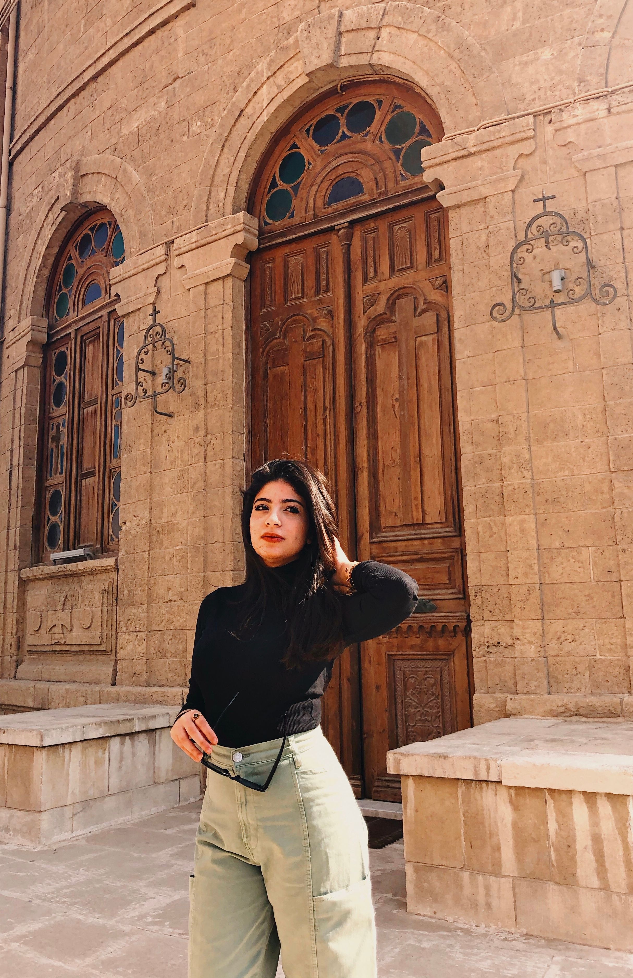 Woman in black top standing outside historic building in Cairo, Egypt.