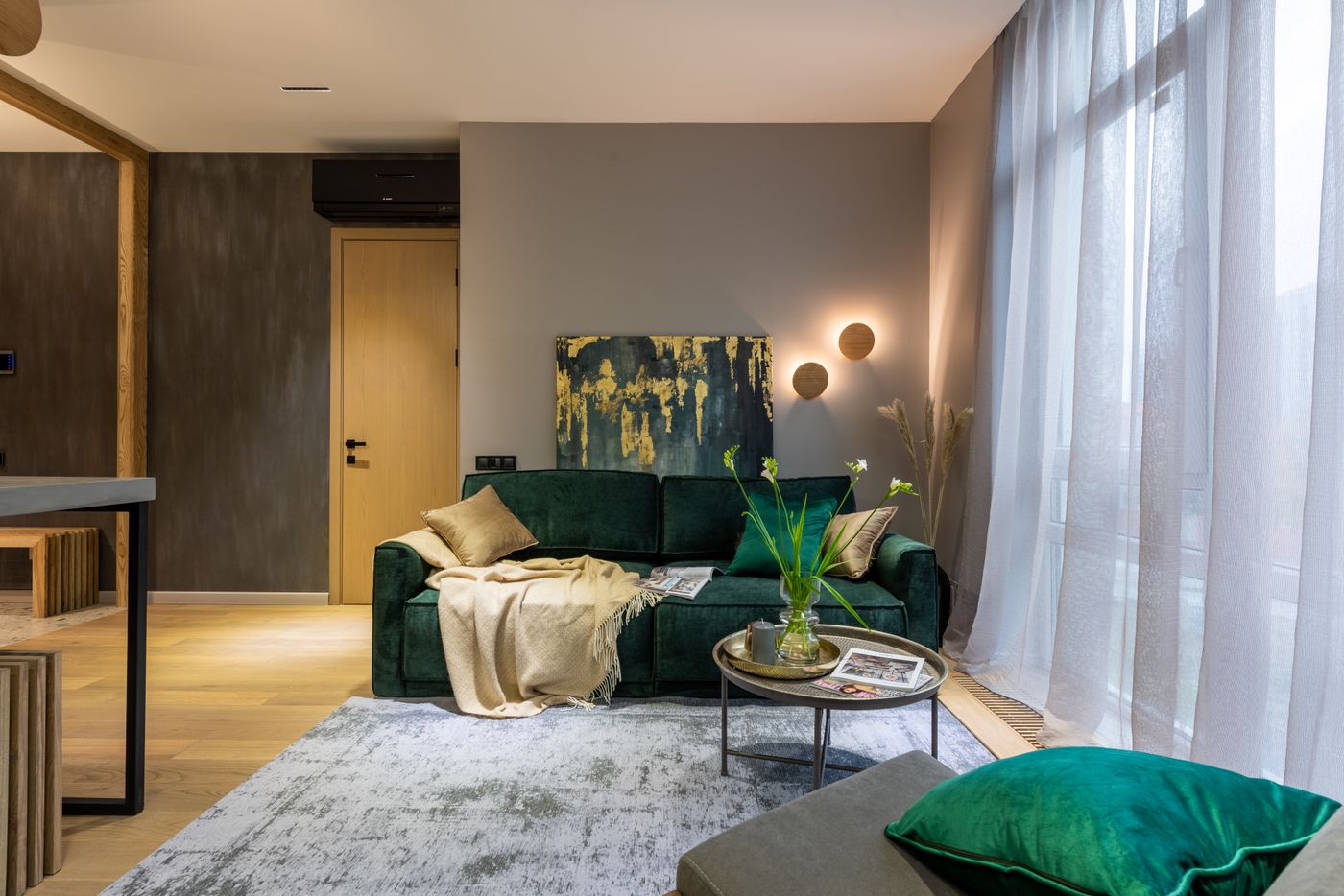 Abstract canvas behind a green velvet sofa — Max Vakhtbovych on Pexels