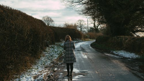 Free Back View of a Woman Walking on Country Road Stock Photo