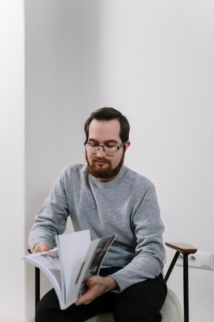 A Man Flipping Pages Of A Magazine