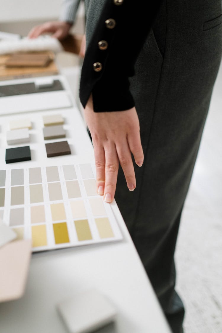 Woman In Black Pants Near Material Samples