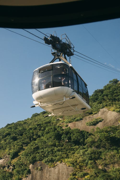 Cable car against green mountain in summer