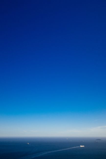 Aerial view of ships sailing on endless ocean under colorful blue sky with clouds in daytime