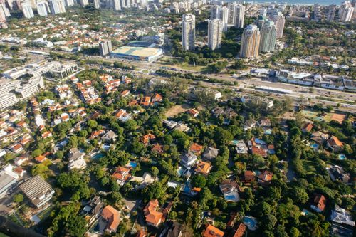 Free Aerial view of dwelling building exteriors and roofs between lush green trees in summer city Stock Photo