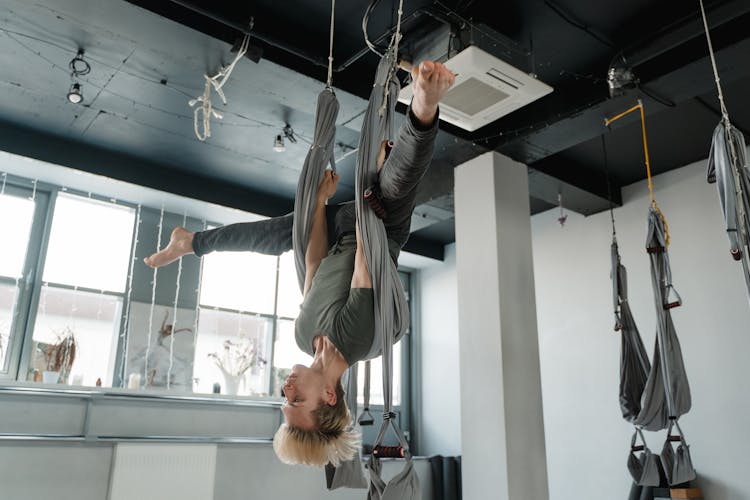 A Man Hanging On An Aerial Yoga Fabric