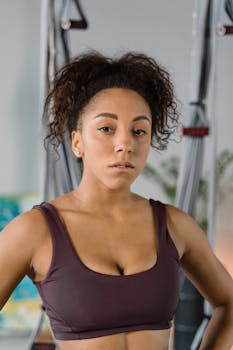 A confident woman in sportswear standing in a gym, exuding strength and determination.