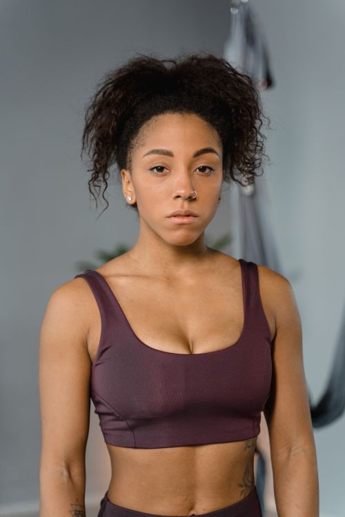 Free Portrait of a fit woman in workout apparel, promoting a healthy lifestyle indoors. Stock Photo