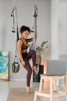 A woman practicing aerial yoga indoors, emphasizing fitness and relaxation.
