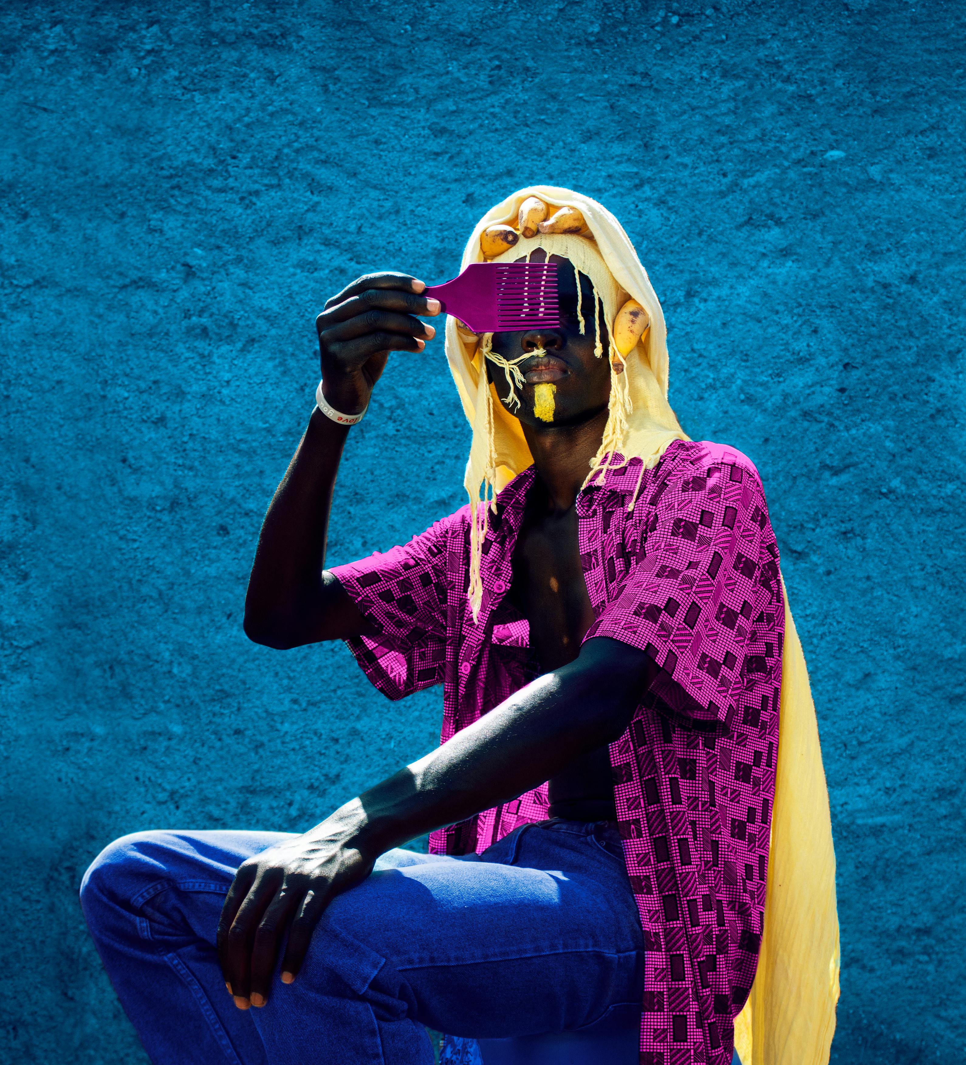 Vibrant portrait of a man using an afro pick, captured in Juja, Kenya.