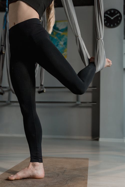 Free Barefooted Woman Using a Yoga Hammock Stock Photo