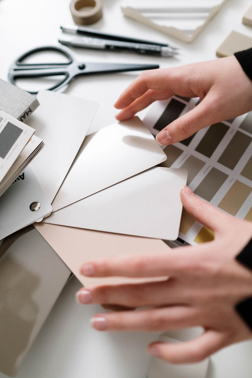 Close-up of hands arranging neutral color swatches on a design workspace.. close, hands, arranging