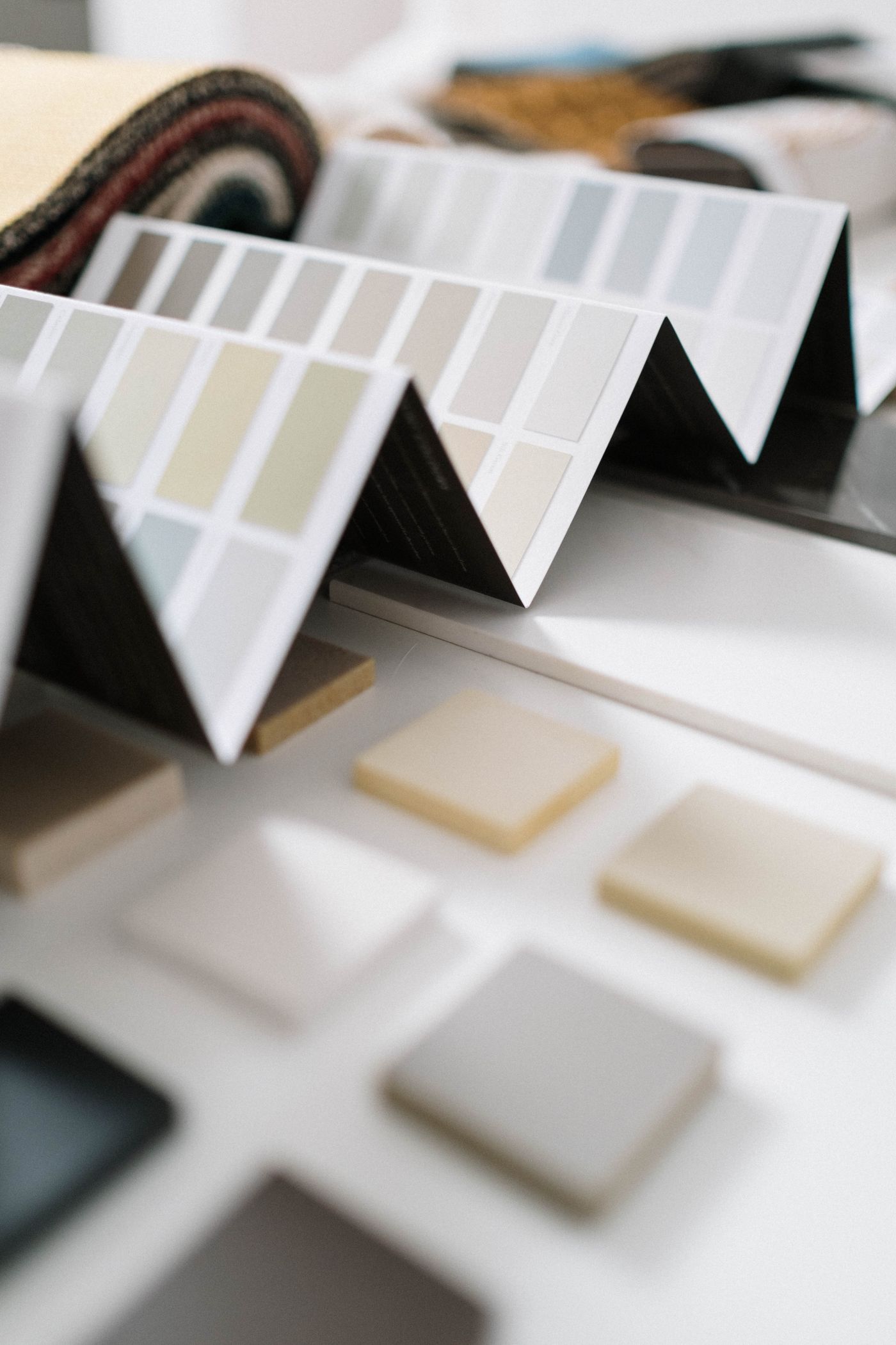 Close-up of neutral paint or finish swatches and sample boards arranged on a design work surface.