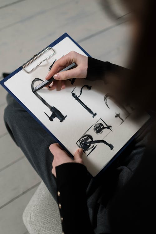 Free Person Sketching With a Pen on a White Paper on Clipboard Stock Photo