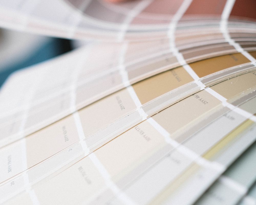 Fanning through paint color swatches to match a shade