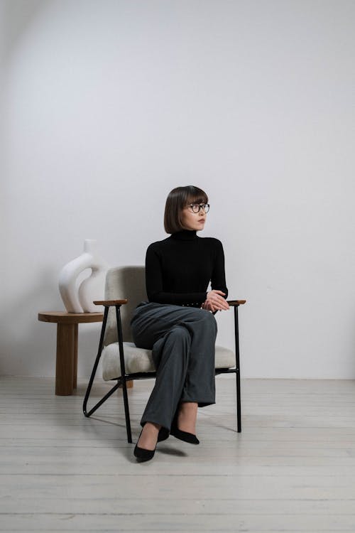 Free A Woman in Long Sleeves Sitting on Chair Stock Photo